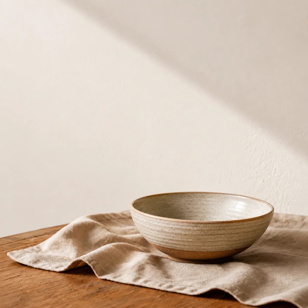 Generated ceramic bowl on linen with the same warm light and neutral palette